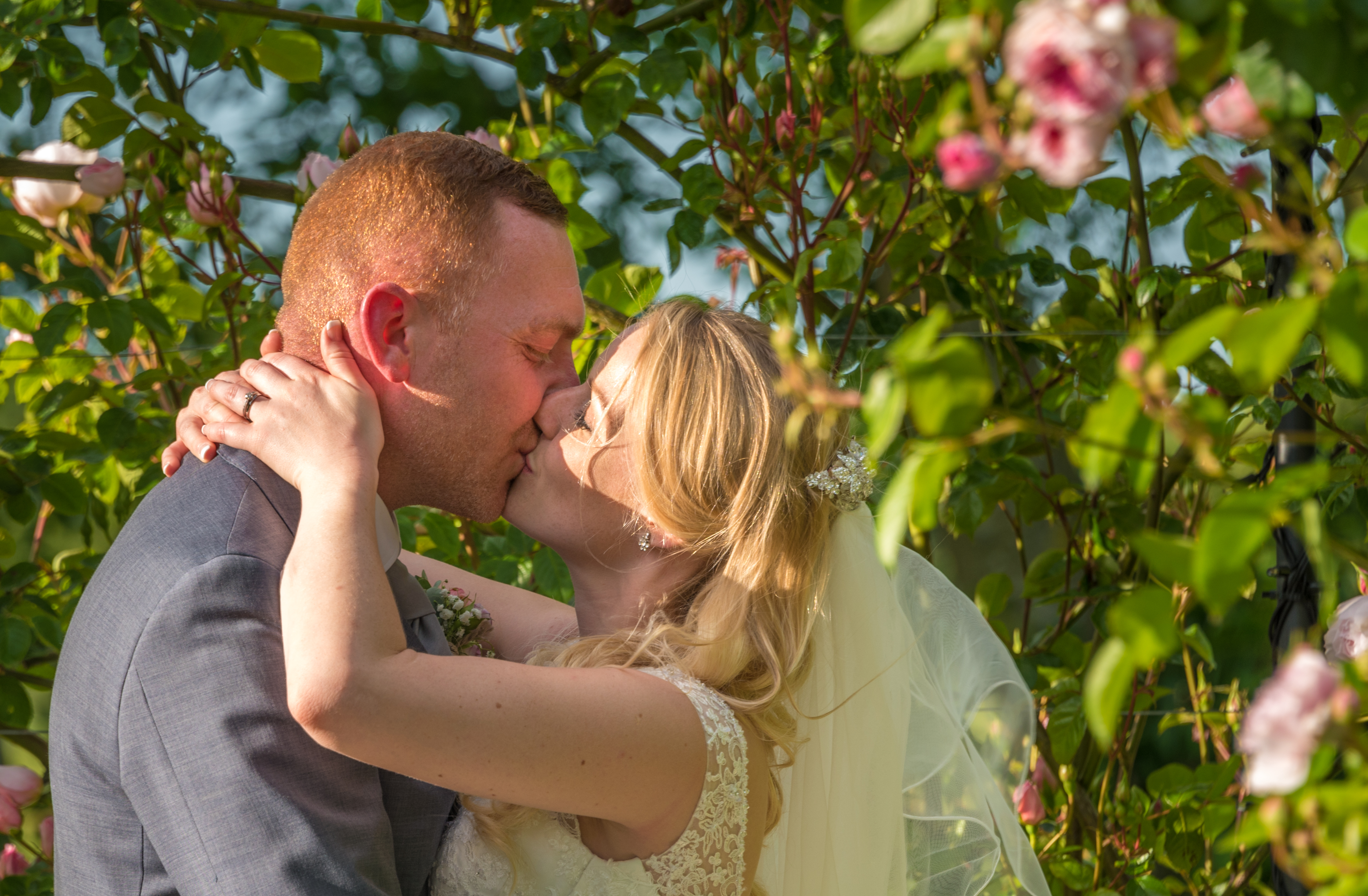 Newlyweds kiss at The Old Kent Barn Wedding Venue in Ashford